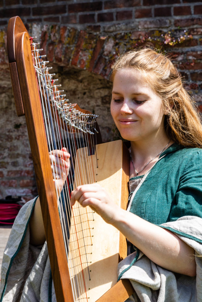 Cathinca die op de harp speelt